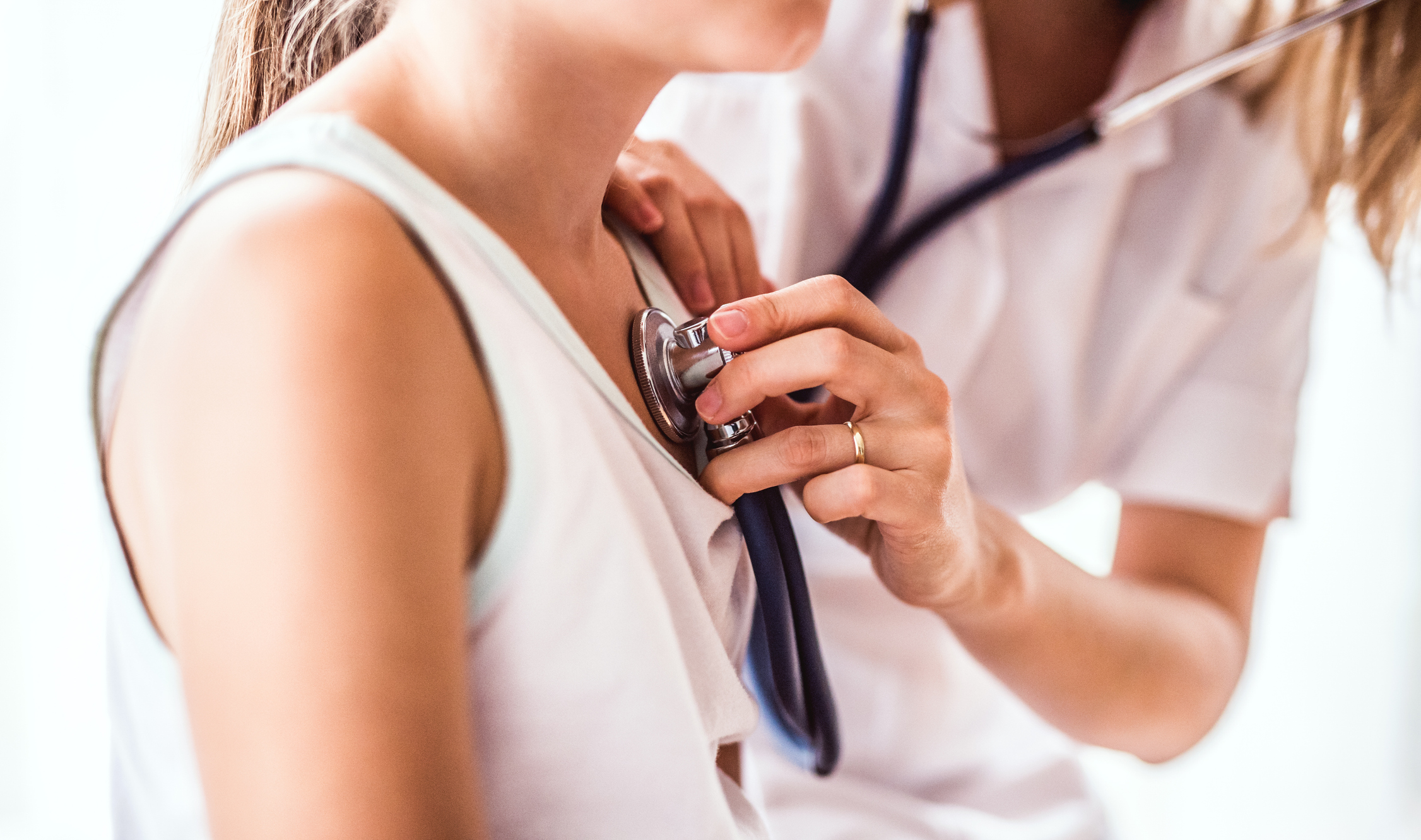 A pediatric doctor listens to her patient's heart with a stethoscope as part of a cardiovascular clinical study.