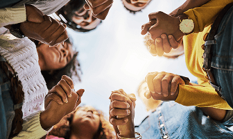 People holding hands and standing in a circle
