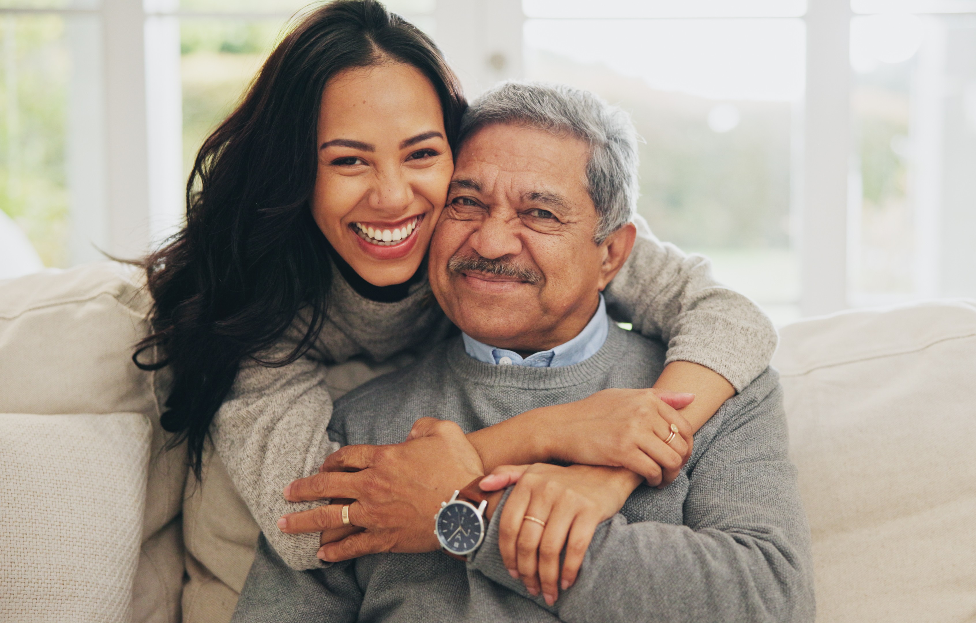 A smiling caregiver hugs a patient who wants to learn how to participate in clinical trials.