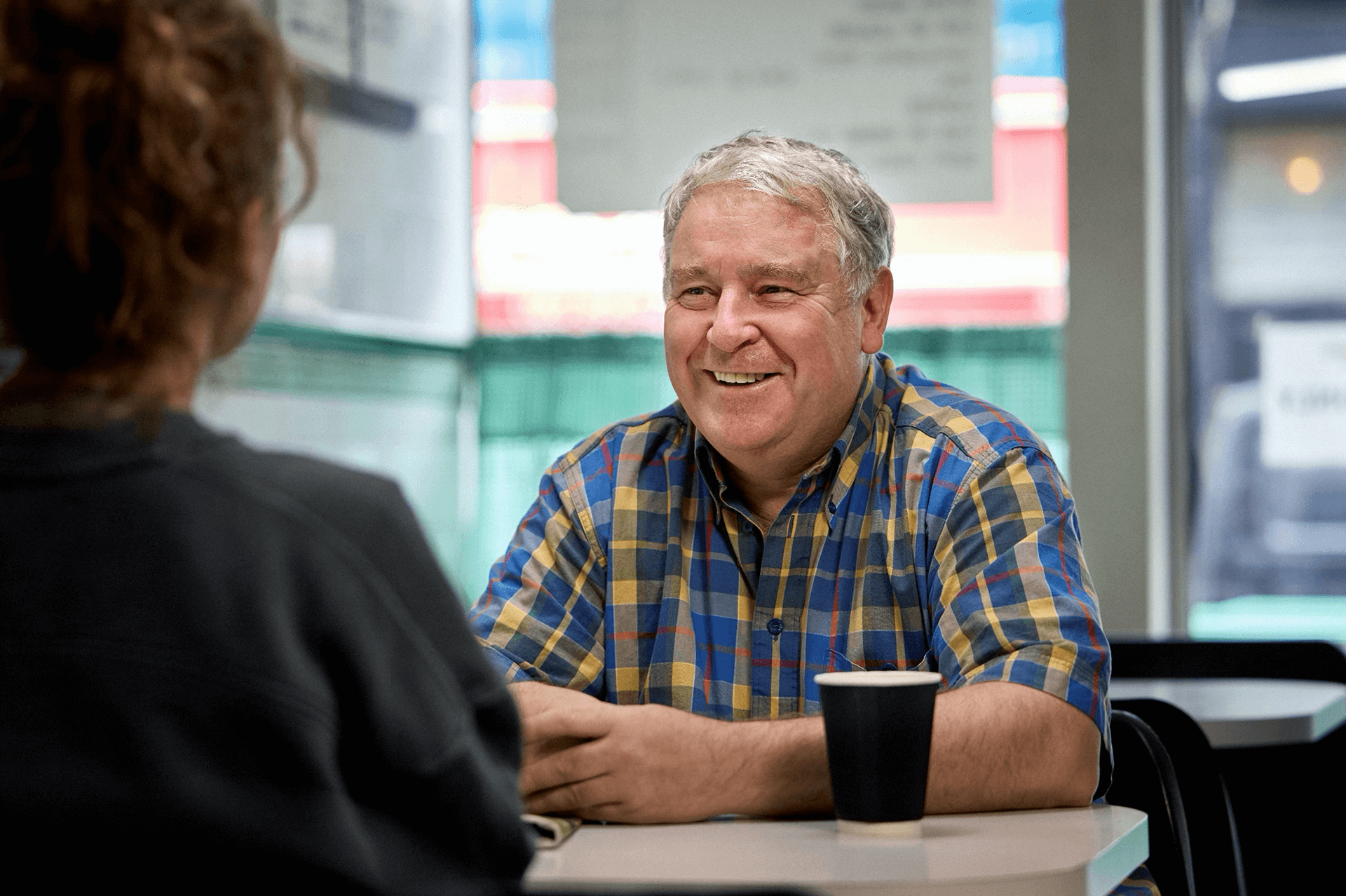 Man smiling while talking to a woman