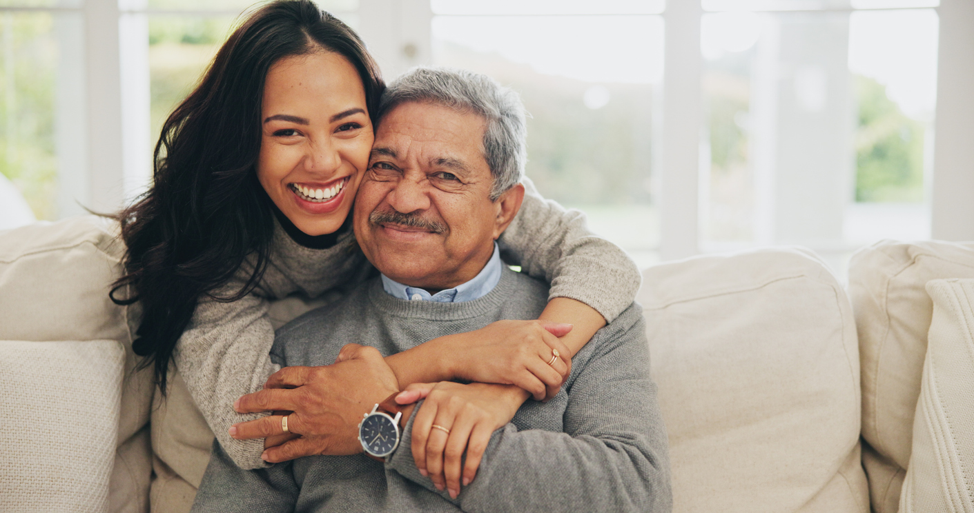 A smiling caregiver hugs a patient who has learned about a research study he may qualify for.