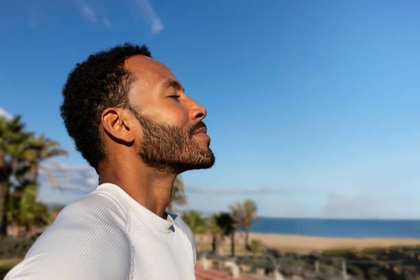 A man breathes deeply at a tropical beach after participating in an asthma clinical study.